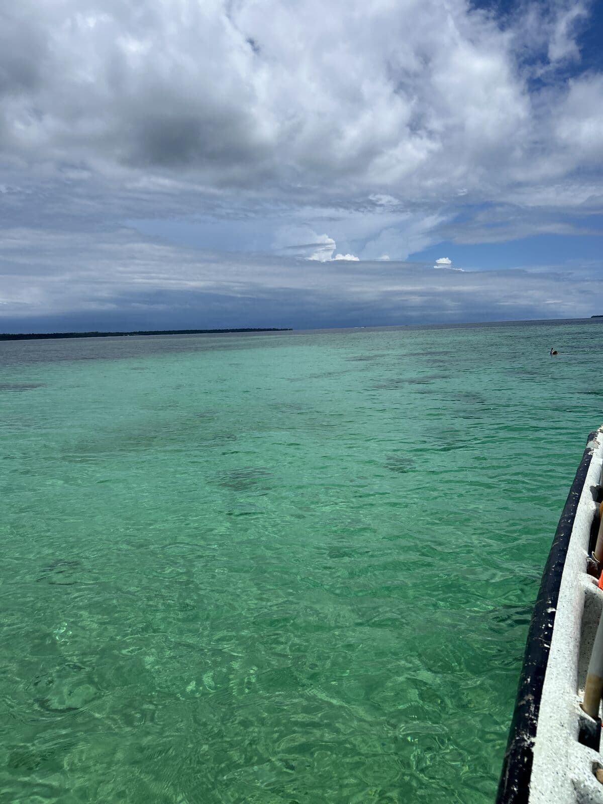 Boat crossing the water between islands — the way every community visit begins
