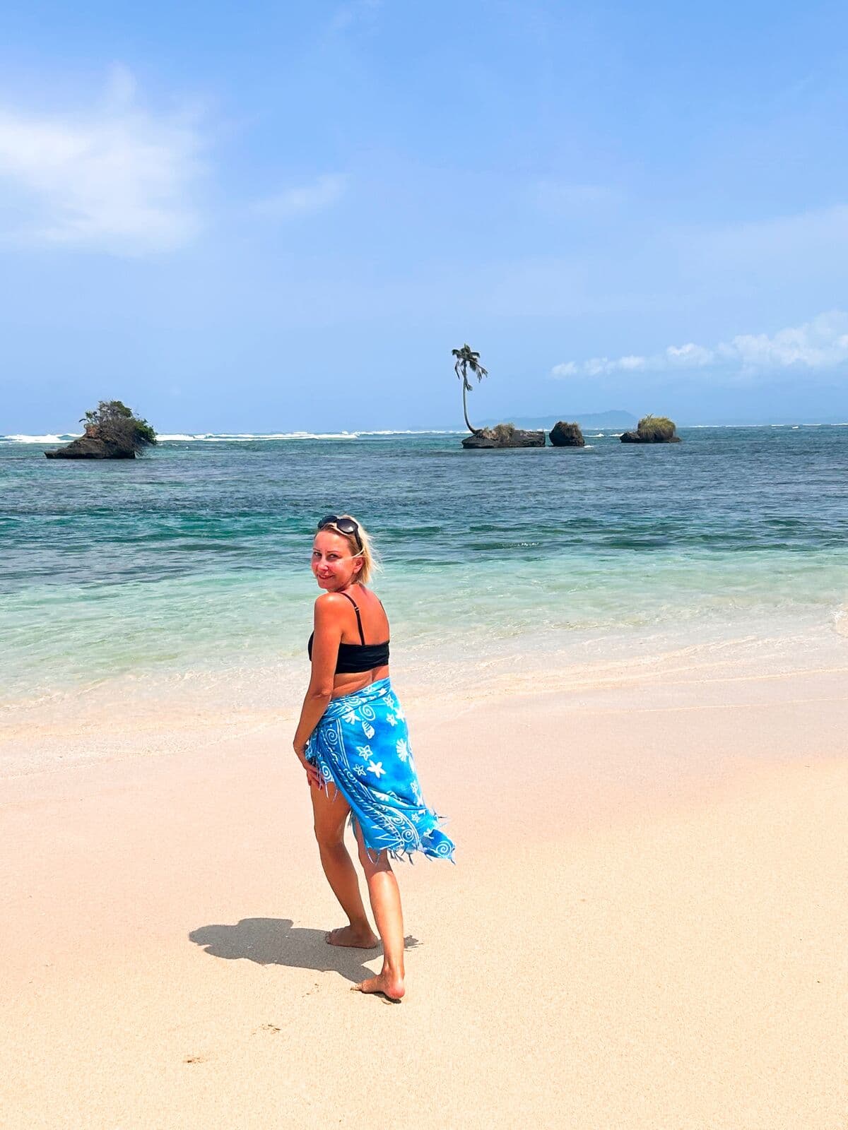 Walking the pink-white sand of Zapatilla Cay at midday